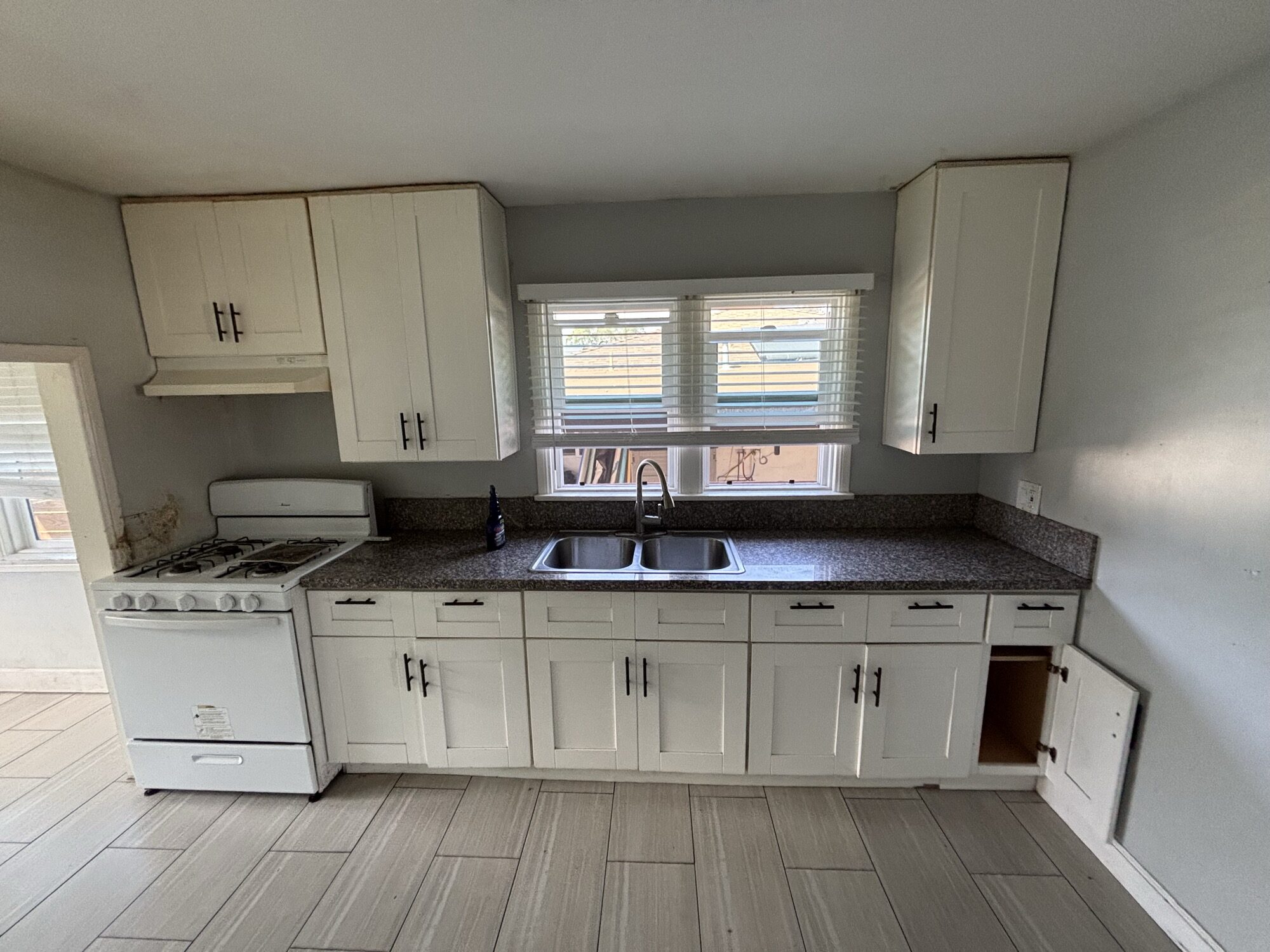 Kitchen before OSR demolition and cleanout in North County San Diego — cabinets, granite counters, sink and range still in place